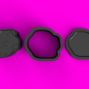 Puede incluir: Tres cortadores de galletas negros, uno con forma de galleta, otro con forma de círculo y otro con forma de nube.