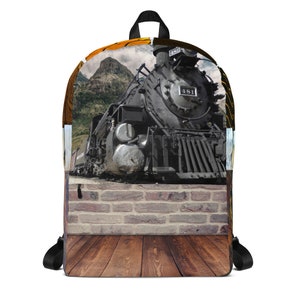 May include: A black and grey steam locomotive with the number 481 on the side, against a backdrop of a brick wall and wooden floor. The locomotive is surrounded by a mountain landscape with a cloudy sky.