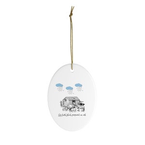May include: A white oval ceramic ornament with a black and white illustration of Noah's Ark with animals and people. The text "By faith Noah prepared an ark" is written below the ark. Three blue clouds with rain are above the ark.