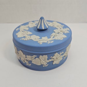 Peut inclure: Une boîte à bijoux en céramique bleue et blanche avec un motif de vigne. Le couvercle a un petit bouton pointu.