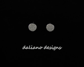 May include: A pair of silver stud earrings with a round, sparkly design.