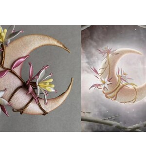 May include: Embroidered crescent moon with floral accents. The moon is a soft pink color with gold stitching around the edges. Delicate white and pink flowers with yellow centers and brown stems adorn the moon's surface.