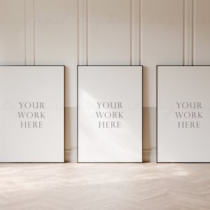 以下が含まれることがあります： 白い背景に「Your Work Here」という文字が書かれた黒い額縁のポスターが3つ。ポスターは白い壁に飾られています。