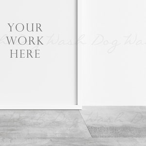 以下が含まれることがあります： 白い壁に白い枠で囲まれた空白があり、「YOUR WORK HERE」と書かれています。壁は灰色のコンクリートの床に面しています。