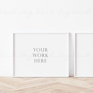 May include: Two white picture frames on a light wood floor. The frame on the left has the text "YOUR WORK HERE" inside.