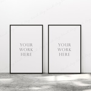 May include: Two black framed posters with white backgrounds and the text "YOUR WORK HERE" in black.