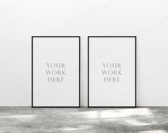 May include: Two black framed posters with white backgrounds and the text "YOUR WORK HERE" in black.