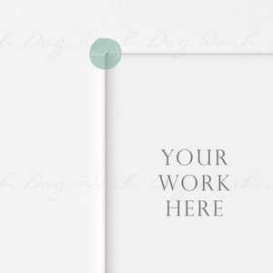 K&ouml;nnte beinhalten: Wei&szlig;er Bilderrahmen mit einem wei&szlig;en Passepartout und dem Text "YOUR WORK HERE" in der Mitte.