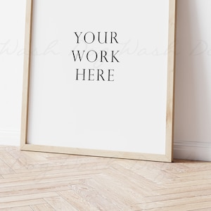 May include: A simple wooden frame with a white background and the text "YOUR WORK HERE" in black.