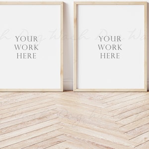 May include: Two light wood picture frames with white mats are hanging on a white wall. The frames are empty and ready for your artwork.