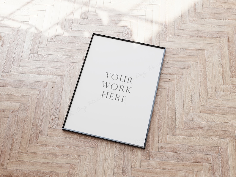 May include: A black picture frame with a white mat and the text "YOUR WORK HERE" on a light wood floor.