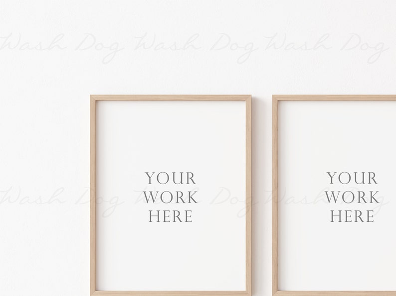 May include: Two light wood framed posters with white mats and the text "YOUR WORK HERE" centered on each poster.
