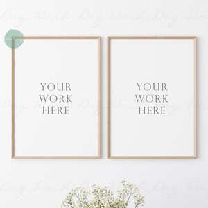 May include: Two light wood framed posters with white mats and white backgrounds. The text "YOUR WORK HERE" is printed in black on each poster.