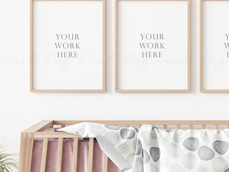 May include: Three wooden picture frames with white mats and a white background. The frames are hanging on a white wall above a wooden crib with a pink and white blanket. The text "YOUR WORK HERE" is printed in the center of each frame.