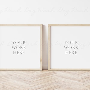 May include: Two square wooden picture frames with a light wood finish, hanging on a white wall. The frames are empty and have the text "YOUR WORK HERE" printed inside each frame.