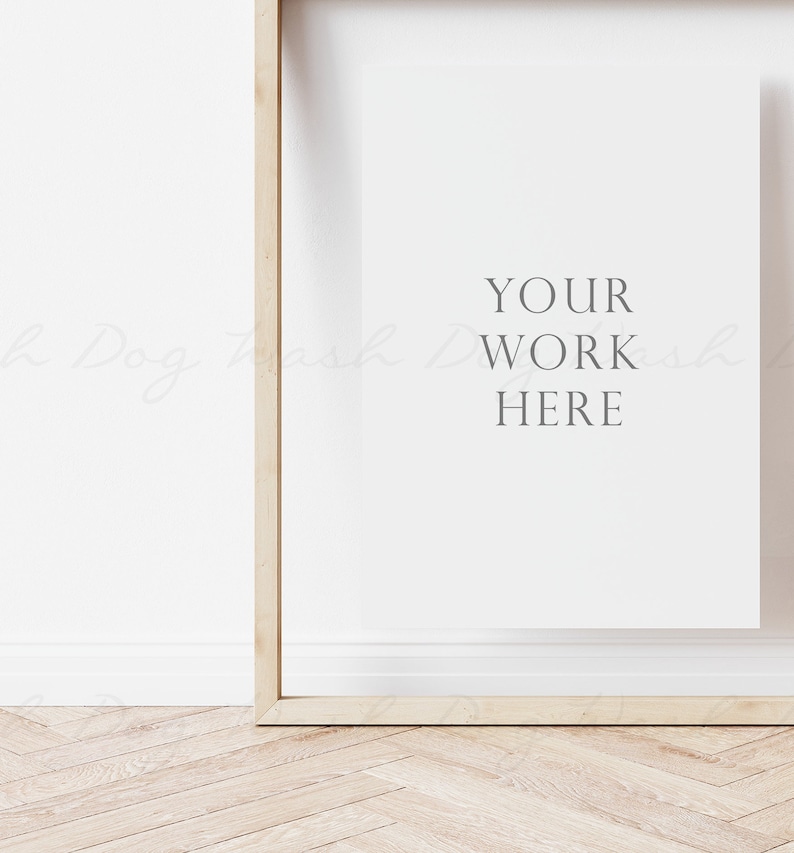 May include: A wooden frame with a white mat and the text "YOUR WORK HERE" in gray lettering. The frame is on a light wood floor.