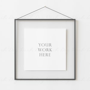 Puede incluir: Un marco negro con un paspartú blanco y una tarjeta blanca en el interior. La tarjeta tiene el texto "YOUR WORK HERE" impreso en ella.