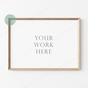 Peut inclure: Un cadre en bois clair simple avec un fond blanc. Le texte "YOUR WORK HERE" est imprimé au centre du cadre.