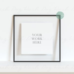 Op de afbeelding: Een zwart fotolijstje met een witte passe-partout en een witte kaart erin. Op de kaart staat de tekst "YOUR WORK HERE".