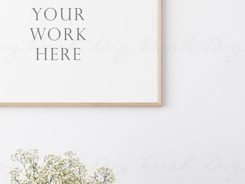 May include: A white frame with a wooden border, hanging on a white wall. The frame is empty and has the text "YOUR WORK HERE" written in grey text.