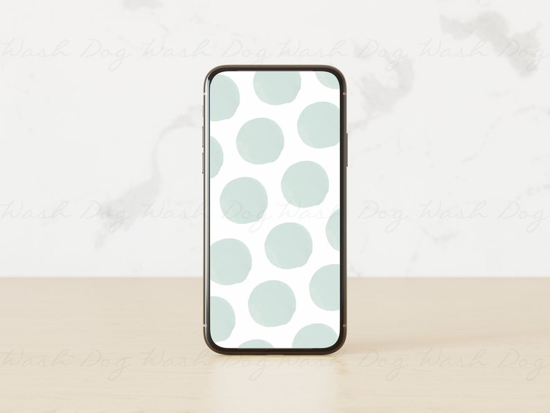 May include: A smartphone with a white background and a pattern of light blue circles. The phone is on a light wood surface.