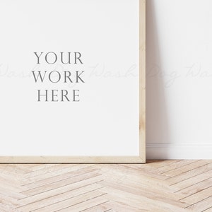May include: A light wood frame with a white background and the text "YOUR WORK HERE" in the center. The frame is sitting on a light wood floor with a herringbone pattern.
