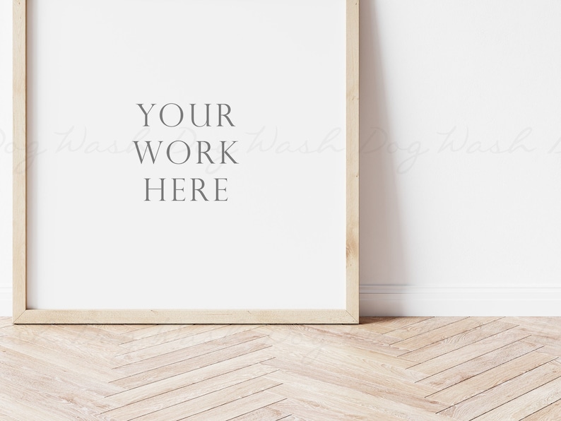 May include: A light wood frame with a white background and the text "YOUR WORK HERE" in the center. The frame is sitting on a light wood floor with a herringbone pattern.