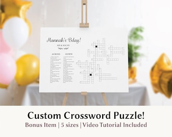 May include: A white rectangular sign on a wooden easel featuring a custom crossword puzzle titled Hannah's Bday! Sip & Solve. The sign includes numbered across and down clues and a grid of empty squares for filling in answers.