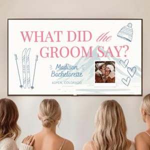 Puede incluir: Un gran letrero blanco con el texto "WHAT DID the GROOM SAY?" en rosa. El letrero incluye una foto, ilustraciones de esquís y el texto "Madison Bachelorette Aspen, Colorado". Un grupo de mujeres mira el letrero.
