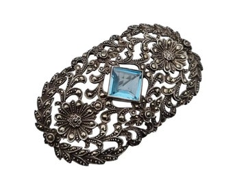 Art nouveau brooch in 935 silver with a central blue stone, decorated with marquisitas flowers, very striking, Antique and vintage jewelry.