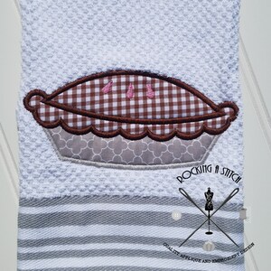 May include: White kitchen towel with a brown and gray embroidered pie design. The towel has gray stripes and the text "Rocking a Stitch Quality Applique and Embroidery Design".