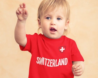 Camiseta infantil ou para bebês da Suíça com nome e bandeira da Copa do Mundo de 2026.