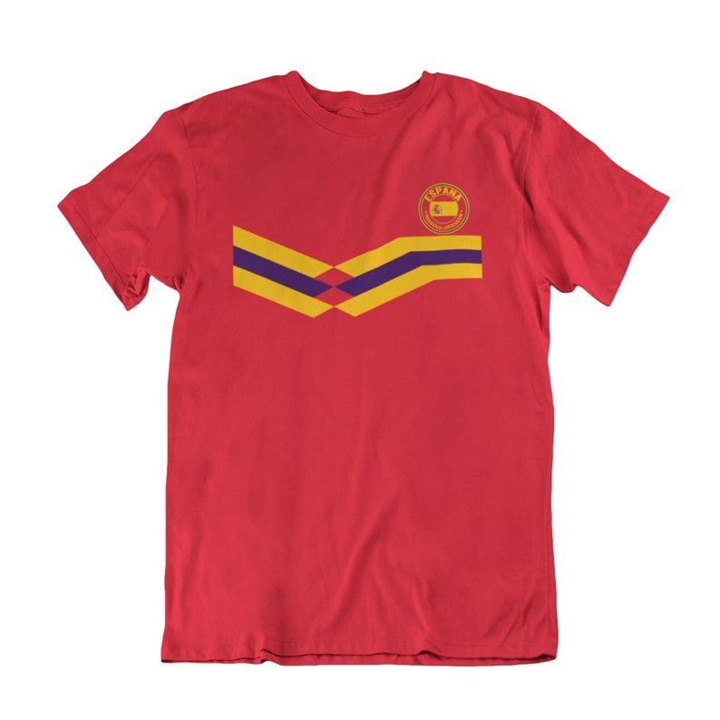 May include: Red t-shirt with a yellow and purple chevron design and a circular logo with the word "ESPANA" in the center.