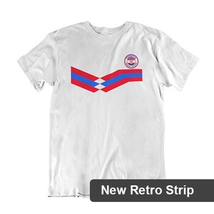 May include: White t-shirt with a red, white, and blue stripe design and a red, white, and blue circle with the word "Croatia" on it.