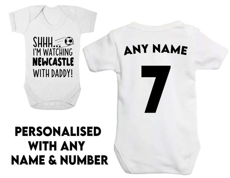 Peut inclure: Combinaison b&eacute;b&eacute; blanche avec texte noir qui dit "SHHH... I'M WATCHING NEWCASTLE WITH DADDY!" et un graphique de ballon de football noir. Combinaison b&eacute;b&eacute; blanche avec texte noir qui dit "ANY NAME" et le num&eacute;ro "7".