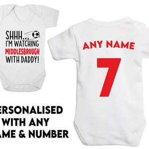 Könnte beinhalten: Zwei weiße Baby-Bodys. Ein Body hat den Text "SHHH... I'M WATCHING MIDDLESBROUGH WITH DADDY!" und eine Fußballgrafik. Der andere Body hat den Text "ANY NAME" und die Nummer "7" in Rot.