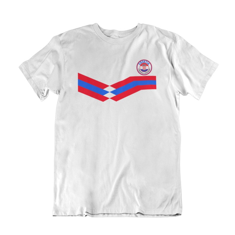 May include: White t-shirt with a red, white, and blue chevron design and a circular logo with the word "Croatia" in the center.
