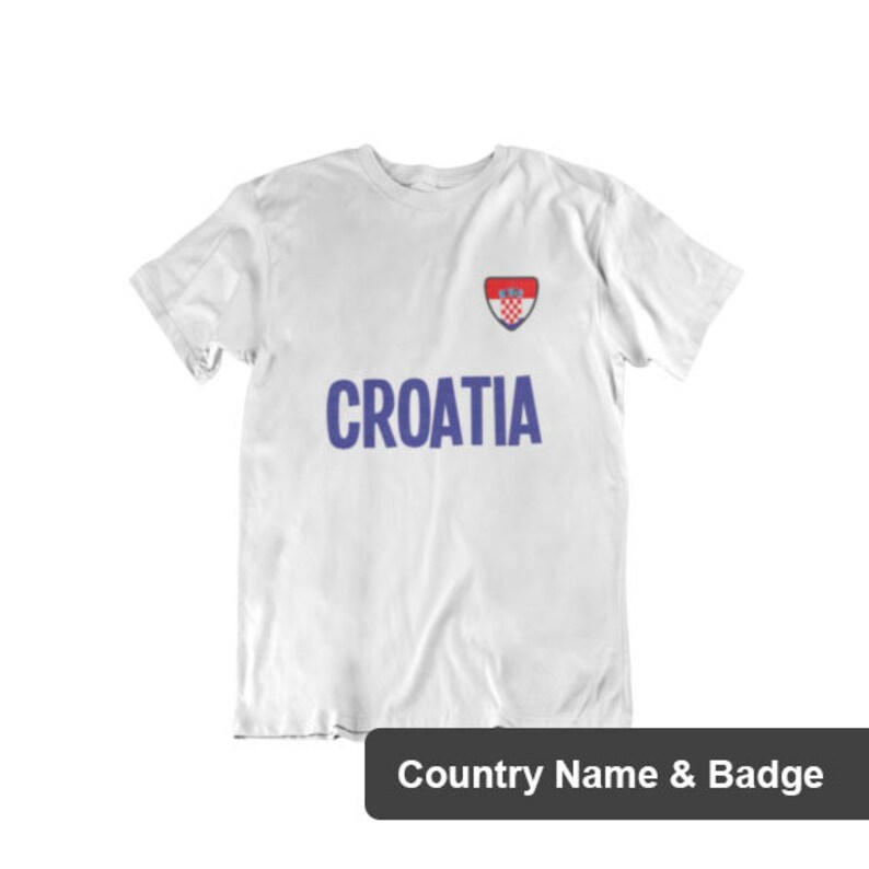 May include: White t-shirt with the word "CROATIA" printed in blue letters and a red, white, and blue Croatian flag badge.
