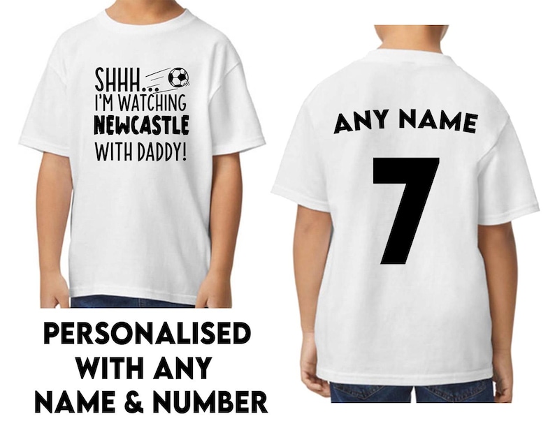 Peut inclure: Deux t-shirts blancs, l'un avec le texte "SHHH... I'M WATCHING NEWCASTLE WITH DADDY!" et un graphique de ballon de football, et l'autre avec le texte "ANY NAME" et le num&eacute;ro "7" imprim&eacute; au dos.