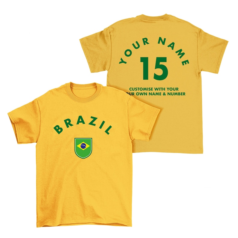 May include: Yellow t-shirt with a green "BRAZIL" arc and a green and blue Brazilian flag in a shield. The back of the shirt is yellow with green text that says "YOUR NAME 15 CUSTOMISE WITH YOUR OWN NAME & NUMBER".