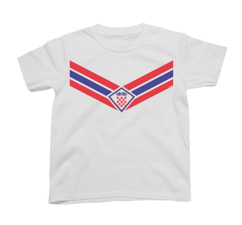 Puede incluir: Camiseta blanca con un dise&ntilde;o de chevron rojo, blanco y azul y el escudo de armas croata en el centro.