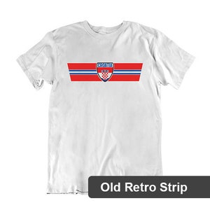 May include: White t-shirt with a red, white, and blue stripe design and the word "Croatia" in blue letters. The Croatian national team crest is in the center of the stripe. "Old Retro Strip" is printed below the image.