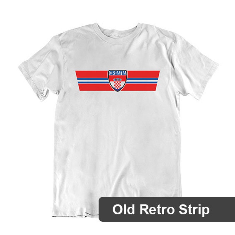 May include: White t-shirt with a red, white, and blue stripe design and the word "Croatia" in blue letters. The Croatian national team crest is in the center of the stripe. "Old Retro Strip" is printed below the image.