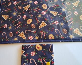 May include: A navy blue fabric pouch with a clear plastic window and a red zipper featuring a red tassel, alongside a smaller matching fabric wallet with a yellow snap button. Both items feature a festive print of candy canes, cookies, and stars.