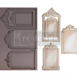 May include: A grey silicone mould featuring three ornate frame designs, alongside four finished decorative frames in white and gold. The mould has the text "re-design with prima" and "DIY simple".