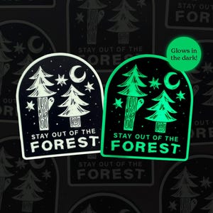 May include: Two stickers with a forest theme. One is black and white, the other glows in the dark. Both feature trees, stars, and a crescent moon, with the text "STAY OUT OF THE FOREST".