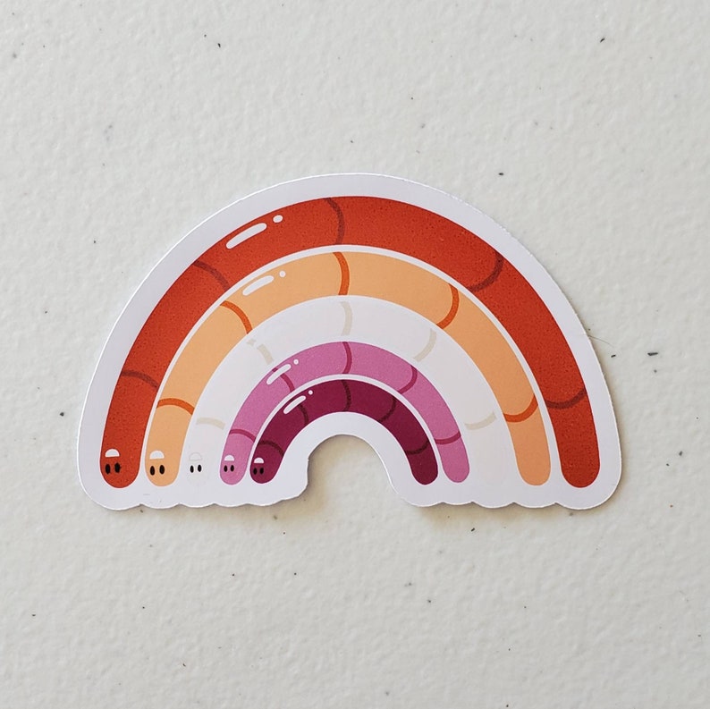 May include: A rainbow-coloured sticker with a design of a rainbow made of worms. The rainbow is in the colours of the lesbian pride flag: red, orange, yellow, pink, purple, and red.