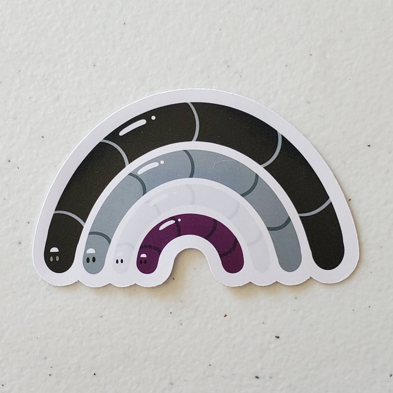 May include: A black, grey, and purple rainbow sticker with a white background. The rainbow is made up of three curved lines, each with a different colour. The top line is black, the middle line is grey, and the bottom line is purple.