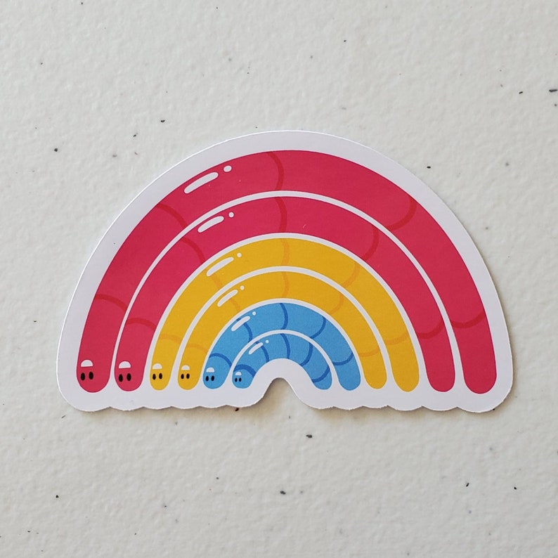 May include: A rainbow sticker with three layers of colour: red, yellow, and blue. Each layer has a slightly different texture, giving the rainbow a 3D effect.