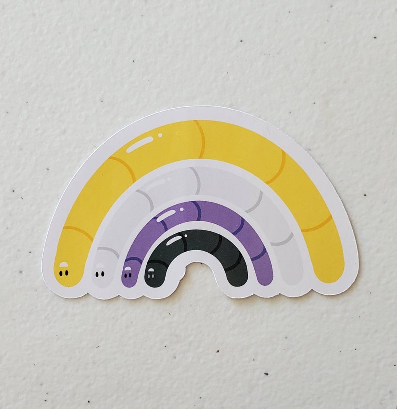 May include: A rainbow-coloured sticker with three curved lines in yellow, white, purple, and black. The sticker is shaped like a rainbow arch.